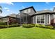 Exterior view of home showcasing screened patio, manicured lawn, and colorful landscaping at 3363 Morelyn Crest Cir, Orlando, FL 32828