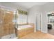 Well-lit bathroom with a separate tiled shower, soaking tub, and view into a bedroom at 3363 Morelyn Crest Cir, Orlando, FL 32828