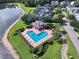 Stunning aerial view of a community pool, nestled next to a lake with ample seating and lush landscaping at 3363 Morelyn Crest Cir, Orlando, FL 32828