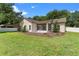 A backyard featuring a screened-in lanai, green grass, and mulch beds around the exterior walls at 3618 Pompano Ct, Gotha, FL 34734