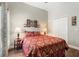 Comfortable bedroom featuring a decorative red patterned bedspread, closet, and hardwood floors at 3618 Pompano Ct, Gotha, FL 34734