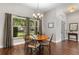 Cozy dining area with hardwood floors, chandelier, and a large window offering a view of the outdoors at 3618 Pompano Ct, Gotha, FL 34734