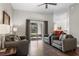 Bright living room boasts hardwood floors, neutral paint, contemporary furnishings, and sliding doors to the outdoors at 3618 Pompano Ct, Gotha, FL 34734