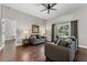 Inviting living room with hardwood floors, ceiling fan, neutral paint, and large window with views of the backyard at 3618 Pompano Ct, Gotha, FL 34734
