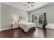 Comfortable main bedroom features hardwood floors, ceiling fan, and a large window with a view of the outdoors at 3618 Pompano Ct, Gotha, FL 34734