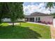 Large backyard with well-maintained lawn, brick patio, black grill, and a white privacy fence at 3994 Knott Dr, Apopka, FL 32712