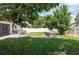Fenced backyard featuring green lawn, shade trees, and an outdoor dining area at 3994 Knott Dr, Apopka, FL 32712