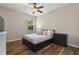 Bedroom featuring dark wood floors, ceiling fan and grey and white linens and pillows at 3994 Knott Dr, Apopka, FL 32712