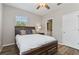 Bedroom featuring a ceiling fan, window, wooden floors, and view of the ensuite bathroom at 3994 Knott Dr, Apopka, FL 32712