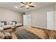 Stylish bedroom featuring wood floors, ceiling fan, and a comfortable seating area at 3994 Knott Dr, Apopka, FL 32712