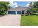 Charming home with a manicured lawn, two-car garage, and inviting entrance with updated stonework at 3994 Knott Dr, Apopka, FL 32712
