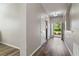 Bright hallway with wood flooring, white trim, and views of the front yard through the doorway at 3994 Knott Dr, Apopka, FL 32712
