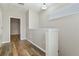 Hallway featuring wood floors, white trim, neutral walls, and natural light from a window at 3994 Knott Dr, Apopka, FL 32712