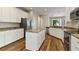 Open-concept kitchen with white cabinets, granite countertops, stainless steel appliances and a central island at 3994 Knott Dr, Apopka, FL 32712