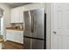 Stainless steel refrigerator with white cabinets and granite countertops in a well-lit kitchen at 3994 Knott Dr, Apopka, FL 32712