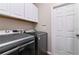 Laundry room with top loading washing machines, white cabinets, and access door at 3994 Knott Dr, Apopka, FL 32712