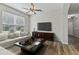 Cozy living room with a large window, ceiling fan, and hardwood floors with a modern entertainment center at 3994 Knott Dr, Apopka, FL 32712
