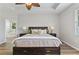 Comfortable main bedroom with tray ceiling, fan, and view of en-suite bathroom at 3994 Knott Dr, Apopka, FL 32712