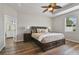 Comfortable main bedroom with tray ceiling, fan, and view of en-suite bathroom at 3994 Knott Dr, Apopka, FL 32712