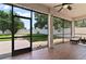 Screened-in patio with stained wood-look flooring, overlooking the green lawn and white fence at 3994 Knott Dr, Apopka, FL 32712