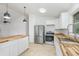 Well-appointed kitchen features white cabinets, wood countertops, stainless steel appliances, and an island at 4085 Cypress Bend, Geneva, FL 32732