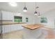 Modern kitchen showcasing white cabinetry, stainless steel appliances, wood countertops, and an eat-in island at 4085 Cypress Bend, Geneva, FL 32732