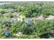 Aerial view of a home with mature trees, canal access, and a private dock showcasing its outdoor amenities at 413 Harbour Oaks Pointe Dr, Edgewood, FL 32809