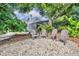 Serene backyard with an outdoor seating area among the rock landscaping, offering a peaceful retreat at 413 Harbour Oaks Pointe Dr, Edgewood, FL 32809