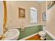 Cozy half bathroom with hardwood floors, decorative mirror, and elegant fixtures at 413 Harbour Oaks Pointe Dr, Edgewood, FL 32809
