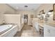 Luxurious bathroom with a soaking tub, dual vanities, and a walk-in closet at 413 Harbour Oaks Pointe Dr, Edgewood, FL 32809