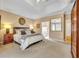 A cozy main bedroom featuring plush carpet, tray ceiling, and ensuite bathroom at 413 Harbour Oaks Pointe Dr, Edgewood, FL 32809