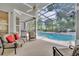 Relaxing screened-in patio with comfortable seating, a ceiling fan, and a view of the sparkling pool at 413 Harbour Oaks Pointe Dr, Edgewood, FL 32809