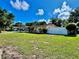 Spacious front yard with lush grass, mature trees, and the charming exterior of the home at 435 Andes Ave, Orlando, FL 32807