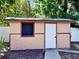 Image features outdoor storage shed with a solid door, window and concrete path at 435 Andes Ave, Orlando, FL 32807