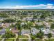 Scenic aerial view of a charming neighborhood with well-manicured lawns, mature trees, and a tranquil lake nearby at 4611 Cranston Pl, Orlando, FL 32812