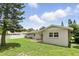 A well-maintained backyard featuring lush green grass, and the home's exterior with white cinderblock walls at 4611 Cranston Pl, Orlando, FL 32812