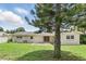 View of the backyard of home featuring large tree, green grass, and a concrete patio at 4611 Cranston Pl, Orlando, FL 32812