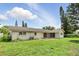 A view of the home's backyard and cinderblock exterior with lawn and some garden growth at 4611 Cranston Pl, Orlando, FL 32812