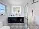 Modern bathroom featuring black and white tile, a dual sink vanity, and a glass-enclosed shower at 4611 Cranston Pl, Orlando, FL 32812