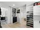 Walk-in closet with custom built-in shelving, drawers, and wood flooring leading to a bedroom at 4611 Cranston Pl, Orlando, FL 32812