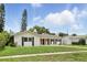 Charming single-story home with well-maintained lawn, classic shutters, and red front door at 4611 Cranston Pl, Orlando, FL 32812