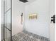 Close-up of the modern glass enclosed shower featuring black and white tile and a rainfall shower head at 4611 Cranston Pl, Orlando, FL 32812