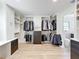 Spacious walk-in closet with custom shelving and storage, featuring light wood floors and a view to the bathroom at 4611 Cranston Pl, Orlando, FL 32812