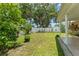 Well-manicured backyard featuring lush landscaping, privacy fence, and covered patio at 470 Cardinal Ct, Kissimmee, FL 34759
