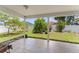 Covered porch overlooking a lush backyard featuring mature trees, a white fence, and a well-maintained lawn at 470 Cardinal Ct, Kissimmee, FL 34759