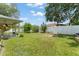Spacious backyard featuring lush grass, a white privacy fence, and mature trees at 470 Cardinal Ct, Kissimmee, FL 34759
