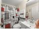 Well-lit bathroom with modern sink and toilet with stylish red, black and grey shower curtain at 470 Cardinal Ct, Kissimmee, FL 34759