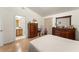 Bright bedroom with hardwood floors, view into bathroom, dresser, and a comfortable bed at 470 Cardinal Ct, Kissimmee, FL 34759