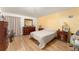 Well-lit bedroom with hardwood floors, dresser, lamps, and a comfortable bed at 470 Cardinal Ct, Kissimmee, FL 34759