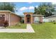 Inviting single-story home with a well-manicured lawn, walkway, and charming arched front door at 470 Cardinal Ct, Kissimmee, FL 34759